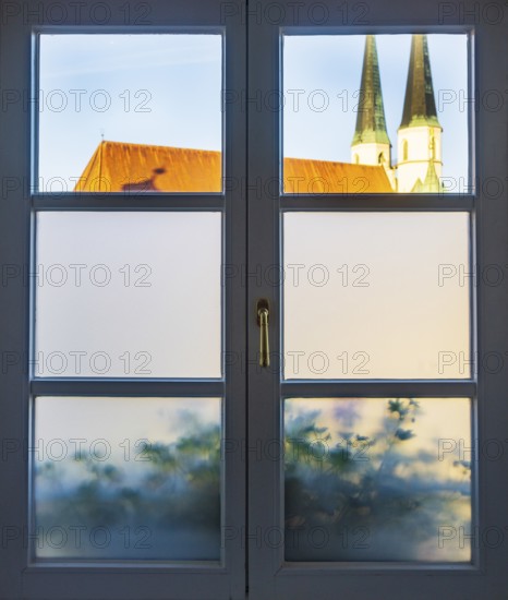 View through a closed window to the collegiate parish church of St Philip and St James, place of pilgrimage, Altötting, Upper Bavaria, Bavaria, Germany