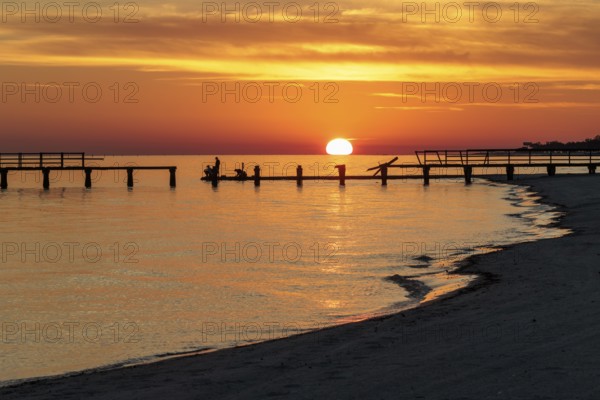 Sunset behind dilapidated fishing pier damaged by hurricanes on the Mississippi Gulf Coast in Long Beach, Mississippi