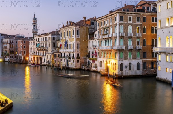 View of the Grand Canal at sunset, picturesque evening mood with illuminated palazzos on the canal and the church tower of the Chiesa Parrocchiale dei Santi Apostoli, long exposure, view from the Rialto Bridge, Venice, Veneto, Italy