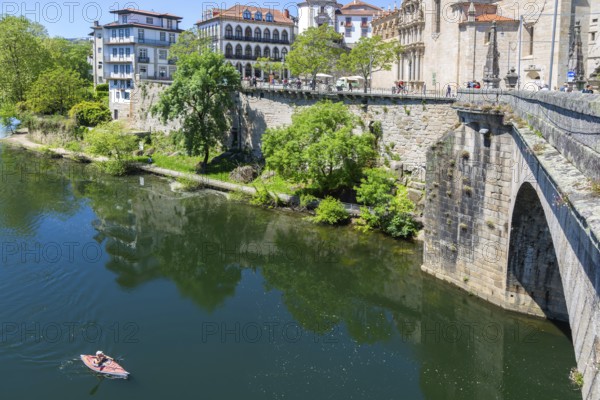 Person kayaking in River Tamega next to historic town centre, Amarante, Portugal