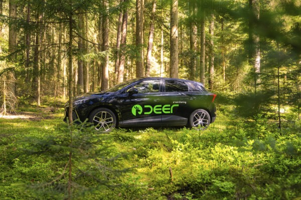 Black car with green stickers parked in a sunny forest, Deer E- Carsharing, Calw, Black Forest, Germany