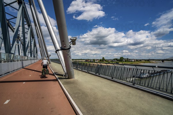 Ride over the Snelbinder Brug bicycle and pedestrian bridge, over the river Waal near Nijmegen, was built on the existing railway bridge, fast cycle path connection from the city centre of Nijmegen and the new housing estates in the Waalsprong district, Netherlands