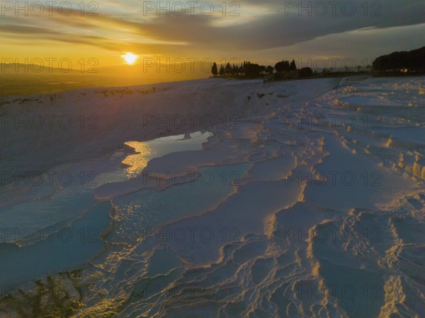 Terraced landscape at sunset with reflecting water and dramatic sky, aerial view, sinter terraces, lime sinter terraces, travertine terraces, Pamukkale, Denizli, UNESCO World Heritage Site, Anatolia, Turkey