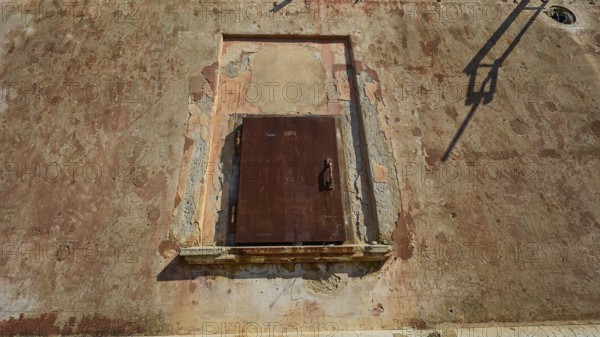 Lost Place, Locked rusty door in a weathered wall under summer light, Radio Station, WW2, Agios Nikolaos Radio, Agia Marina, Leros, Dodecanese, Greek Islands, Greece