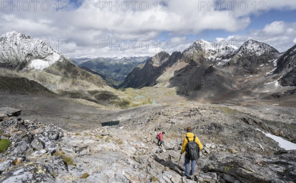 Two mountaineers in a rocky mountain landscape, descending from the summit of Keeskopf, behind them summit of Petzeck, Hoher Perschitzkopf and Kruckelkopf, Schober Group, Hohe Tauern National Park, Carinthia, Austria