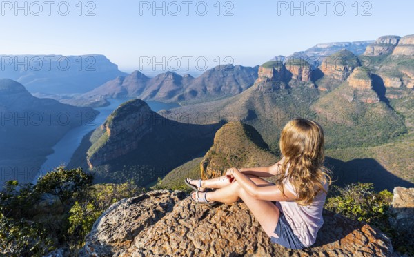 Hiker enjoying sunset at Blyde River Canyon with Three Rondawels peak, view of canyon with Blyde River and table mountains in the evening light, Canyon landscape, Panorama Route, Mpumalanga, South Africa