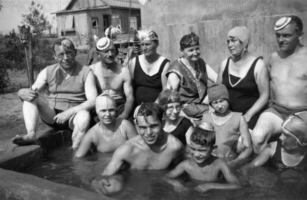 Group in swimming pool, 1930s, A group of people in swimwear posing happily by the pool, Historical photo