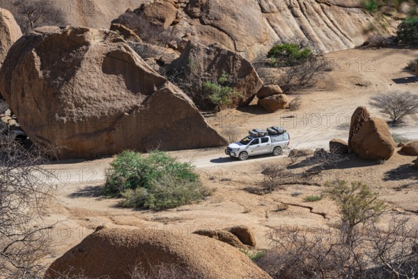 Off-road car between rocks, Pontok Mountains, Great Spitzkoppe, Spitzkoppe, Great Spitzkoppe Nature Reserve, Namibia