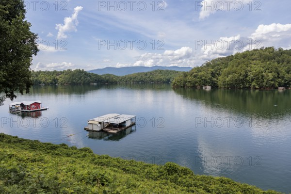 View of a house boats on Fontana Lake as seen from the open air car of the Great Smoky Mountains Railroad on its excursion from Bryson City, North Carolina