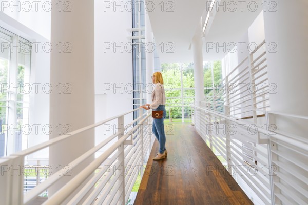 A woman stands in a modern, light-flooded interior with a wooden floor, Frieder Burda Museum, Baden Baden, Germany