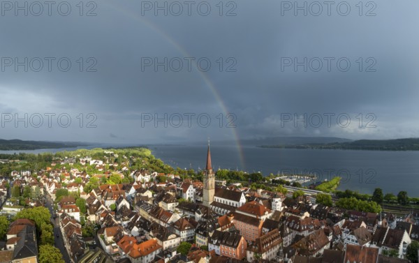 Luftbild von der Stadt Radolfzell am Bodensee mit der historischen Altstadt und dem Radolfzeller Münster nach einem Gewitterschauer von der Abendsonne angestrahlt, am Horizont ein Regenbogen, Landkreis Konstanz, Baden-Württemberg, Deutschland