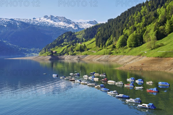 Motorboats moored at the reservoir, snow-covered Alps in the background, Lake Wägital, Canton Schwyz, Switzerland