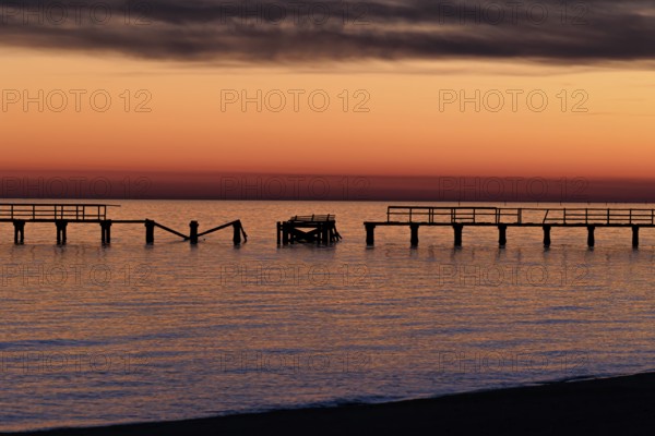 Sunset behind dilapidated fishing pier damaged by hurricanes on the Mississippi Gulf Coast in Long Beach, Mississippi