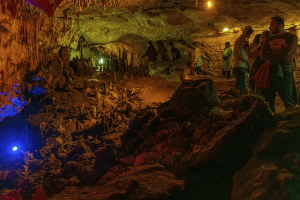 Tourists walking past limestone rock formations in a cave at Florida Caverns State Park in the Florida panhandle near Marianna
