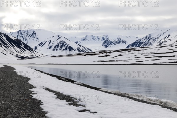 Pebble beach in a bay, mountain range, snow, Mushamna, Spitsbergen, Svalbard