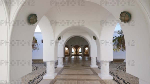 A tranquil area with white arches and hanging plants, framed by decorative arches and lights, Kalithea, Kallithea, thermal baths, thermal spa, bathing complex, Rhodes, Dodecanese, Greek Islands, Greece