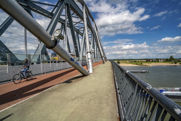 Cycle and pedestrian bridge Snelbinder Brug, over the river Waal near Nijmegen, was added to the existing railway bridge, fast cycle path connection from the city centre of Nijmegen and the new housing estates in the Waalsprong district, Netherlands