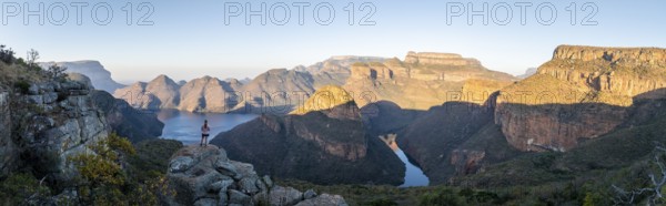 Hiker enjoying panorama, sunset at Blyde River Canyon with Three Rondawels peak, view of canyon with Blyde River and table mountains in the evening light, canyon landscape, Panorama Route, Mpumalanga, South Africa