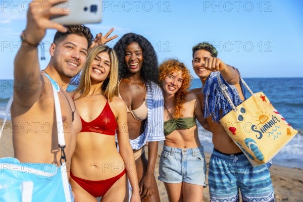 Group of cheerful multi ethnic friends taking a selfie on the beach, enjoying summer holidays together