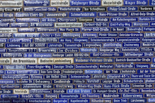 Wall with many blue street signs showing different names, Amorbach, Odenwald, Bavaria, Germany