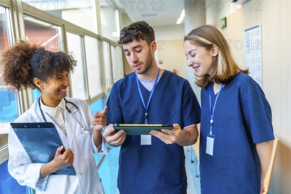 Doctors and nurses reviewing medical records on a tablet, collaborating on patient care in a hospital hallway