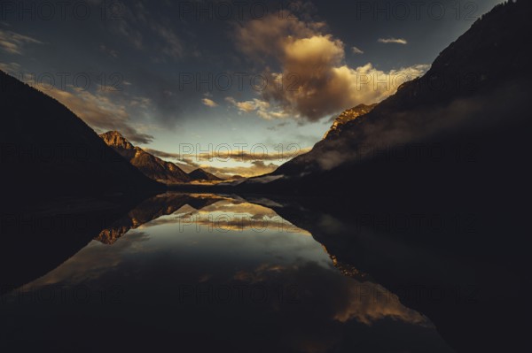 Sunrise with reflections in Lake Heiterwanger See in Tyrol in the Alps in Austria