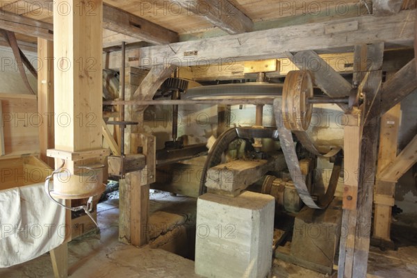 Interior view of mill, wooden construction, wooden beams, wheels, belt, drive wheel, flywheel, flour mill, grinding, historical production of flour, museum, Veßra Monastery, fieldstone, Thuringia, Germany