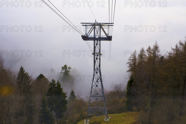 Cableway Tower in the cloud and the Autumn Forest in a Foggy Day on the Mountain in Locarno, Ticino, Switzerland