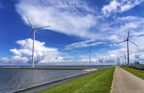 Strekdammen Wind Farm, wind farm at the seaport of Eemshaven in the Netherlands, left, built on offshore breakwaters, 2 GE Cypress 5, 5 MW turbines, with 158 metre blade diameter, together produce 11 MW of power, can supply 15, 500 households with electricity from wind, cumulus cloud over the North Sea, Netherlands