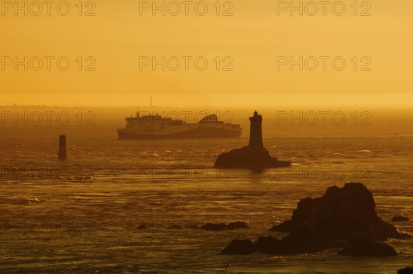 Phare de la Vieille lighthouse and ferryboat at sunset, Pointe du Raz, Cap Sizun, Finistere department, Brittany, France