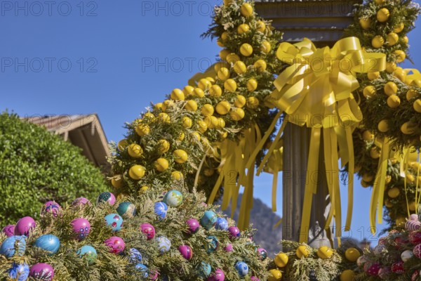 Easter fountain, Easter decoration, blown out coloured Easter eggs, trees, historical buildings, blue sky, cloudless, Florianiplatz, Bad Reichenhall, district Berchtesgadener Land, Bavaria, Germany