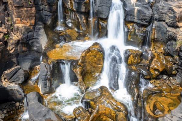 Waterfall on orange-coloured rock cliffs, long exposure, Blyde River, Bourke's Luck Potholes, Panorama Route, Mpumalanga, South Africa