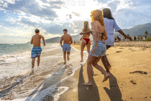 Friends running along the beach, soaking up the sun and enjoying a carefree summer vacation filled with laughter and joy