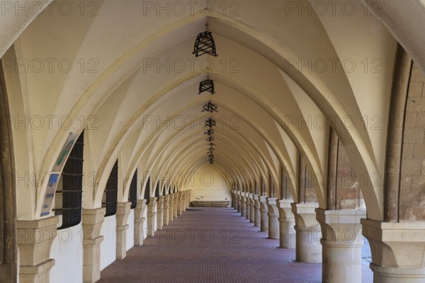 Long covered portico with arches and patterned floor, harbour area, Rhodes Town, Rhodes, Dodecanese, Greek Islands, Greece