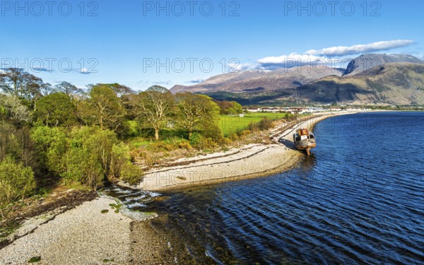View of Corpach Wreck or Old Boat of Caol and Nevis Range Mountains from a drone, Caol Beach, Corpach, Fort William, Highland, Scotland, United Kingdom
