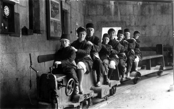 Family on a small railway, 1920s, A family sits together on a small mine train in tunnels, Historical photo