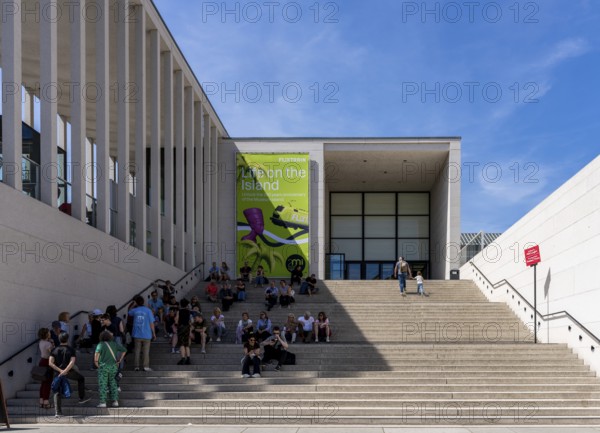 Tourists sitting on the stairs to the James Simon Gallery, Berlin, Germany