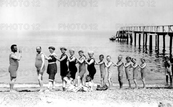 Beach, Baltic Sea, Summer holiday, In a row of organ pipes, 1920s, Group of people in striped swimming costumes on the beach in a row, Lively scene, Historical photo