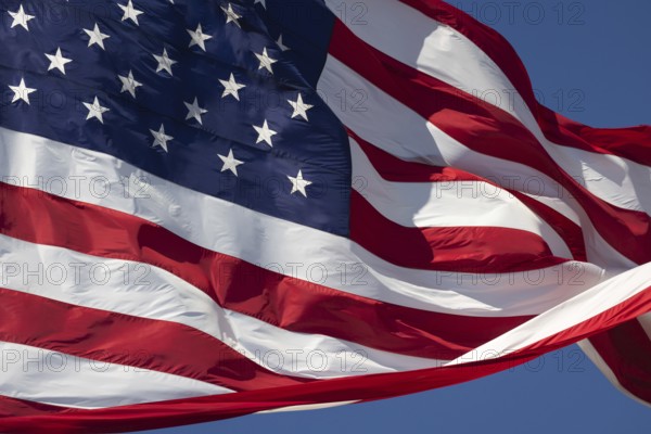 American flag waving in the wind against deep blue sky