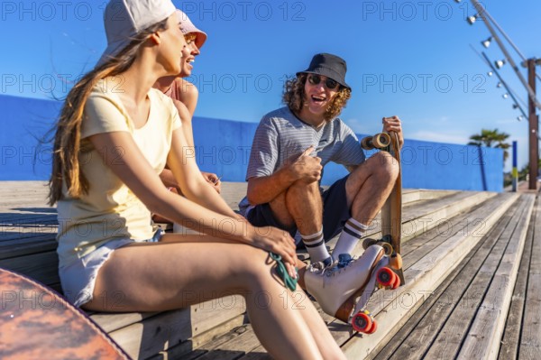 Group of young friends relaxing on wooden steps, enjoying a sunny day with skateboards, embodying a carefree and active lifestyle