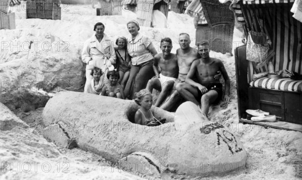 Sand car beach chair family, 1930s, family on the beach posing around a large sand car, relaxed and cheerful, historical photo