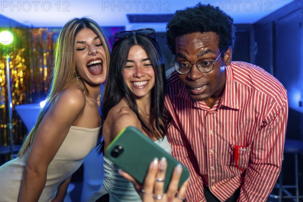 Cheerful multi ethnic friends gathering together, capturing a fun selfie at a vibrant party, enjoying the lively music and nightlife atmosphere