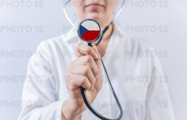 Female doctor holding stethoscope with Czech Republic flag. National health system of Czech Republic