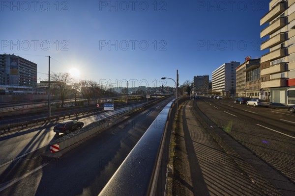 Street, general architecture, modern architecture, metal railings, lanterns, vehicles, parking lane, trees, backlight of the sun, blue cloudless sky, motorway A620, Saaruferstrasse, Saarbrücken, state capital, regional association Saarbrücken, Saarland, Germany