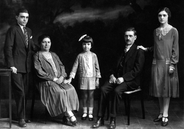 Family with children, 1930s, A family poses formally in a photo studio in elegant clothes, Historical photo