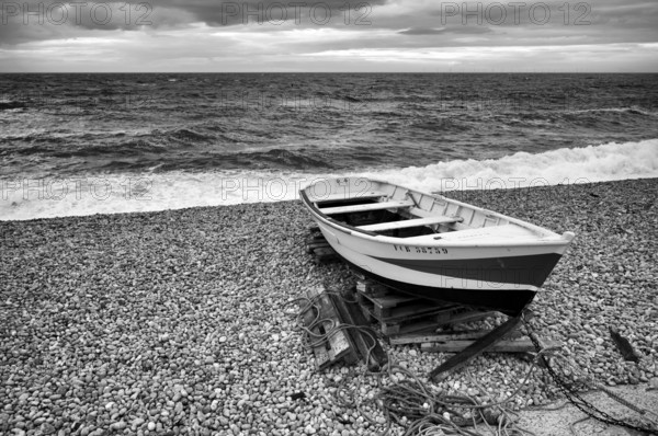Boat, rowing boat, lies on the beach, pebble beach, Étretat, sea, clouds, black and white, Normandy, Seine-Maritime, France