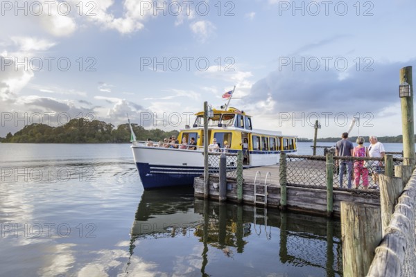 Water taxi boat with passengers approaching the dock of Fort Wilderness campground at Walt Disney World in Orlando, Florida, USA