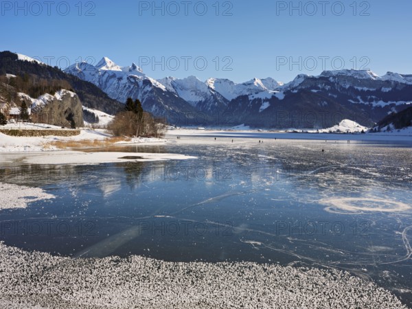 Frozen Sihlsee, reservoir, behind the snow-covered mountains Flübrig and Druesberg, Euthal, Canton Schwyz, Switzerland