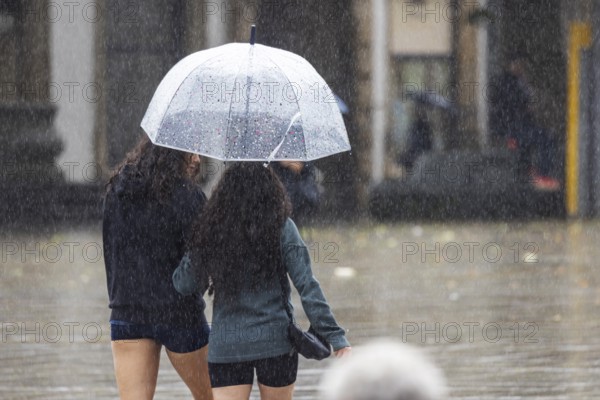 Rainy weather in Stuttgart. People with umbrellas hurry through the rain on Königstraße. Stuttgart, Baden-Württemberg, Germany