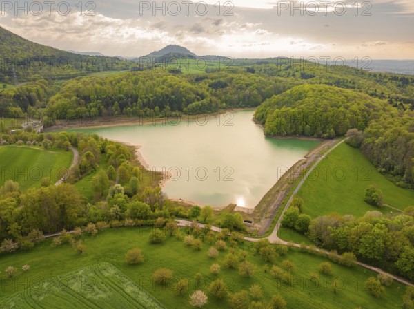 Spring landscape with a lake surrounded by forest between hills, Glems reservoir, Swabian Alb, Germany